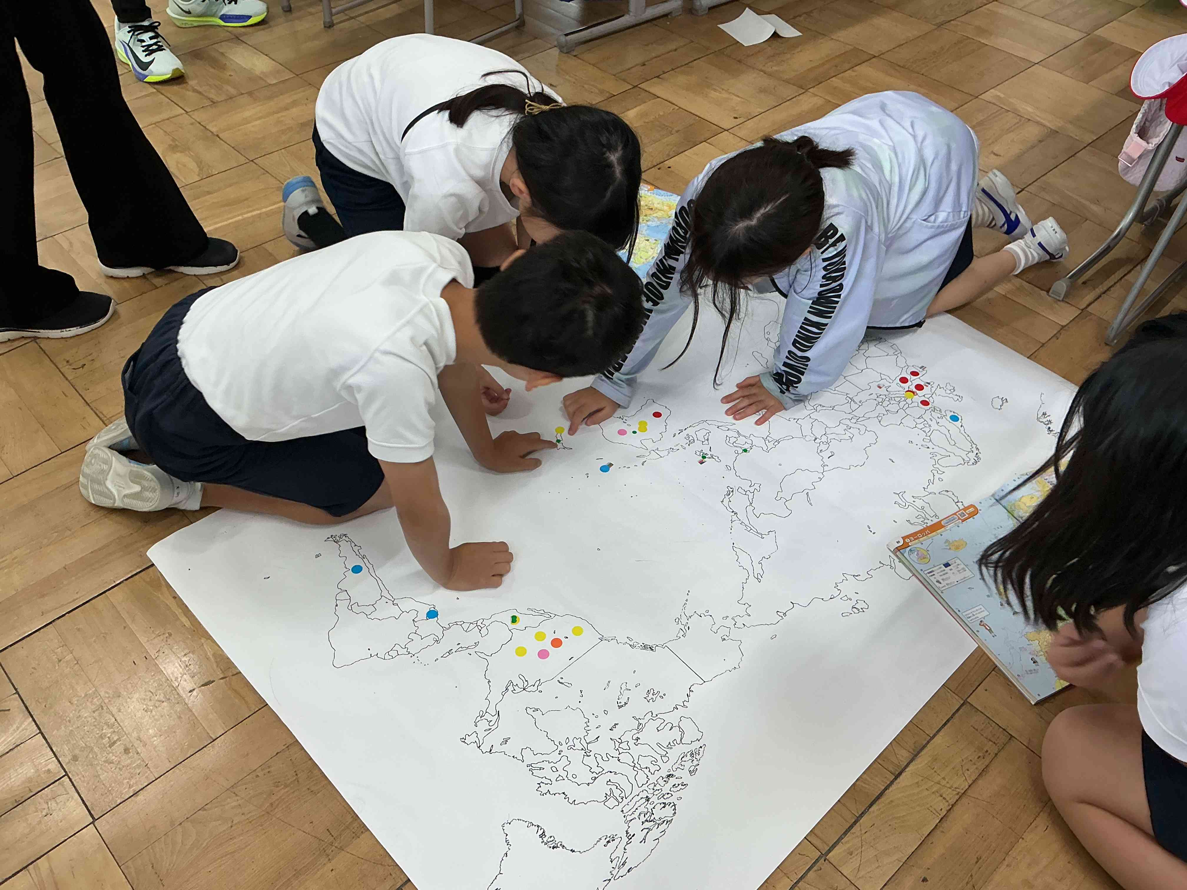 10月30日　社会「店ではたらく人」で品物の産地をラベルで調べて地図に貼っています。とても楽しく、品物、産地の国旗、地理と関連付けて学んでいます。